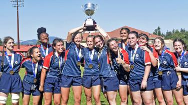 Senior Girls Rugby Team pose for photo holding trophy above their heads (Photo credit: John Morrow/Abbotsford News)