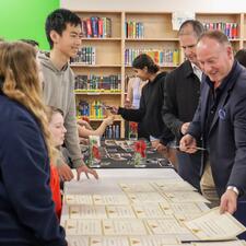 Superintendent Nosek grabbing a certificate from a table